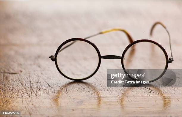 close up antique round glasses on wooden table - bulbo oculare foto e immagini stock