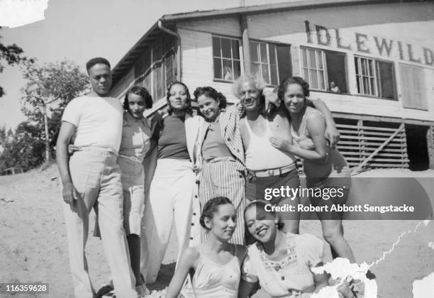 Portrait of a group of unidentified people as they pose on the beach outside the Idlewild Club House, Idlewild, Michigan, September 1938. Idlewild,...