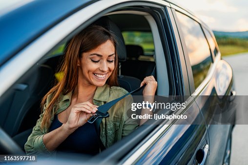 Foto di una donna d'affari seduta in un'auto che mette la cintura di sicurezza Foto di una donna d'affari seduta in un'auto che mette la cintura di sicurezza