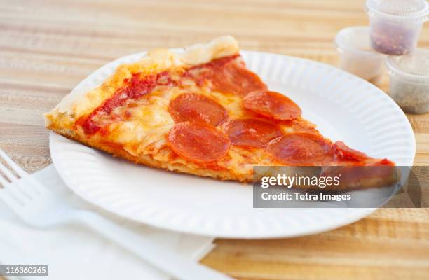 slice of pepperoni pizza on plate - pizza de chorizo fotografías e imágenes de stock