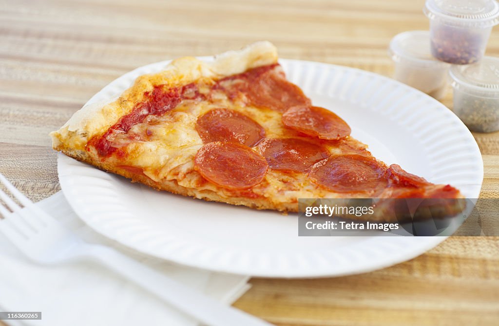 Slice of pepperoni pizza on plate