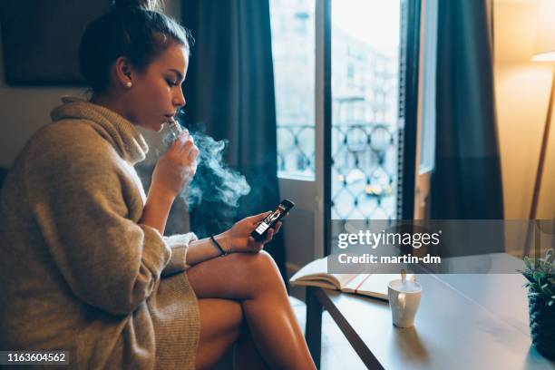 services bancaires en ligne à partir de smartphone - femme et fumeuse photos et images de collection