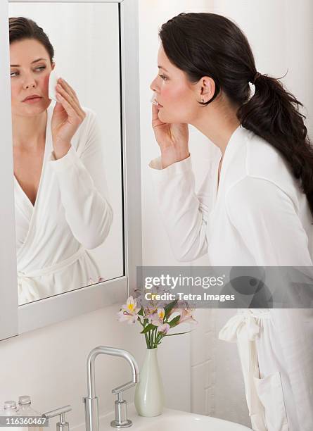 usa, new jersey, jersey city, woman removing make-up in bathroom - make up verwijderen stockfoto's en -beelden