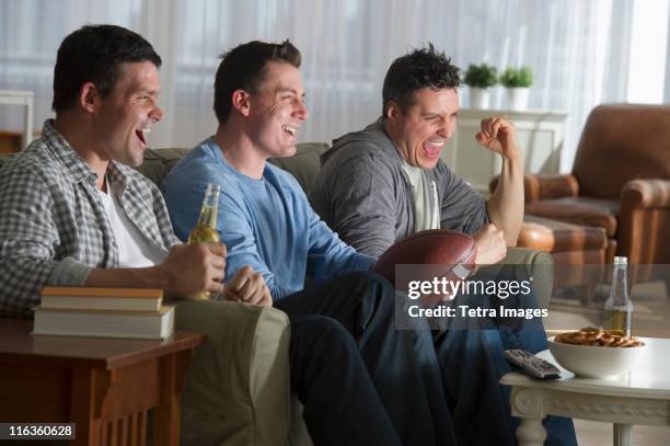 usa, new jersey, jersey city, three men watching television - man cave stock pictures, royalty-free photos & images