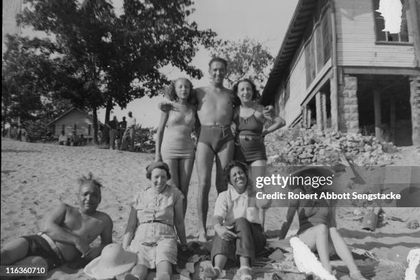 Portrait of a group of unidentified people as they pose on the beach outside the Idlewild Club House, Idlewild, Michigan, September 1938. Idlewild,...