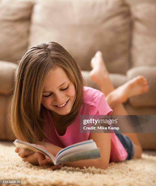 usa, utah, lehi, girl (10-11) lying on rug, reading book - barefoot feet up lying down girl stockfoto's en -beelden