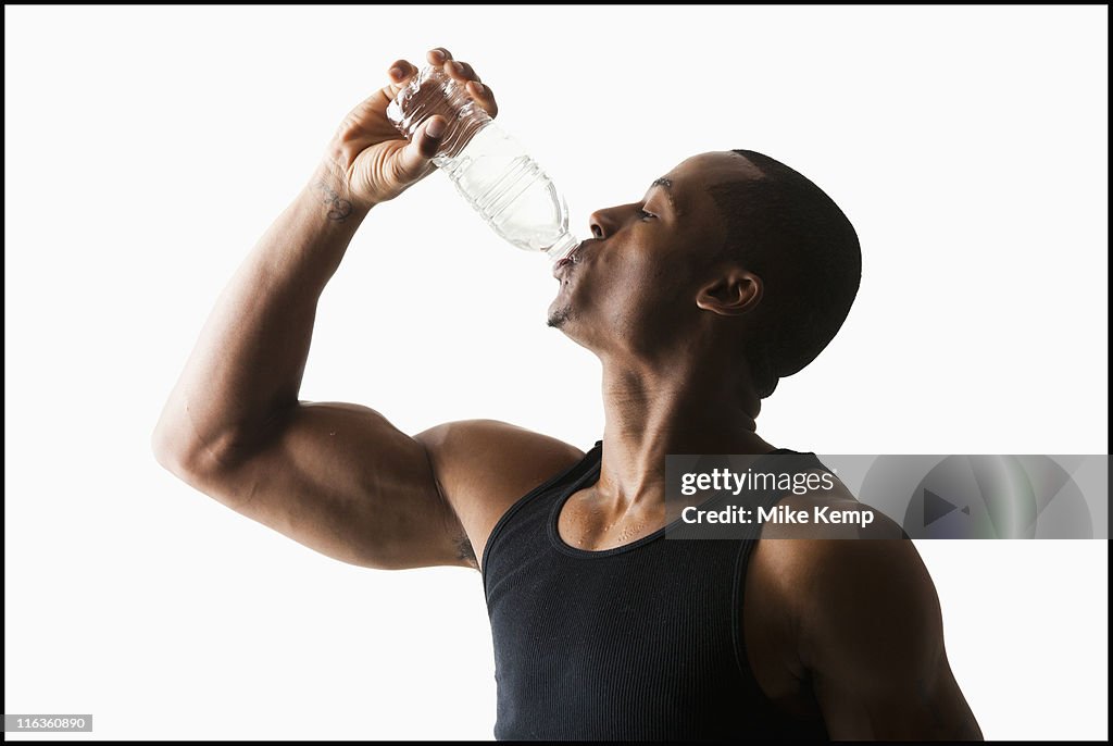 Studio shot of man drinking water from bottle