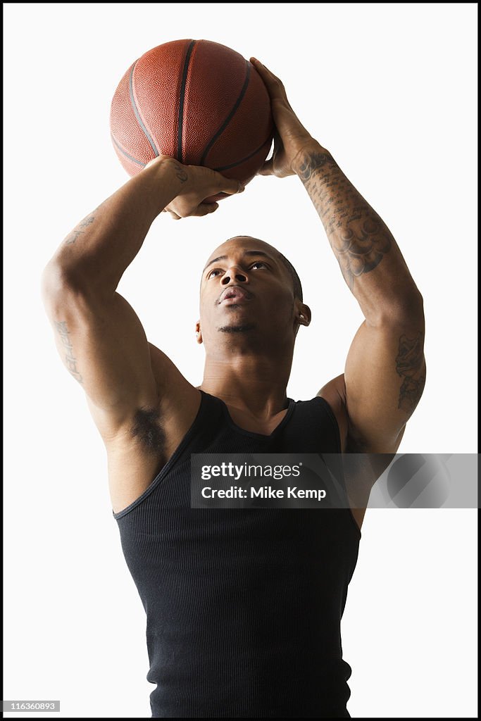 Studio shot of man playing basketball