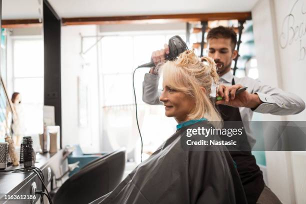 hairdresser with hairdryer - mature woman haircut stock pictures, royalty-free photos & images