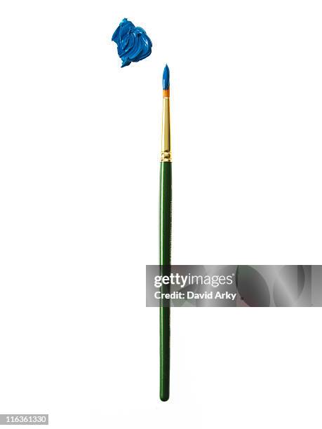 green paintbrush with blue paint on white background - paintbrush stockfoto's en -beelden