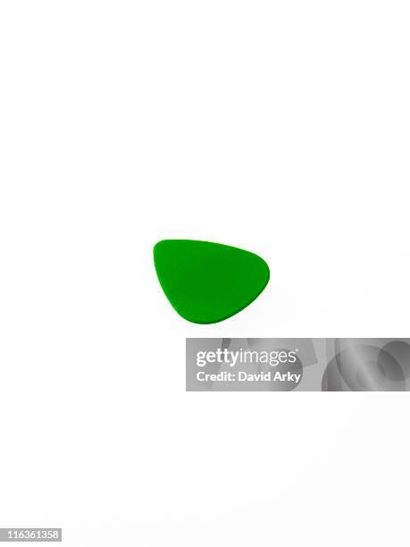 green plectrum on white background - gitaarplectrum stockfoto's en -beelden