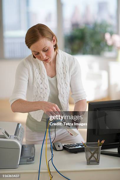 usa, new jersey, jersey city, woman installing router at home office - internet router stock pictures, royalty-free photos & images