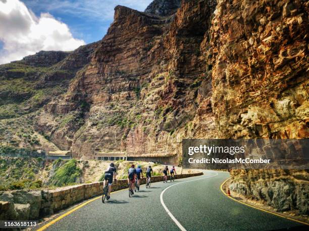 group of cyclists rolling on the chapman's peak drive near cape town - chapmans peak stock pictures, royalty-free photos & images