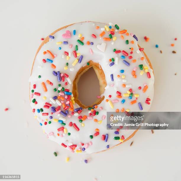 close-up of sprinkled donut - sprinkles stock-fotos und bilder