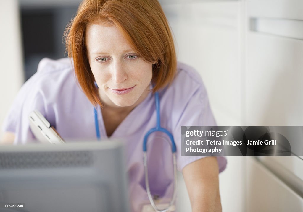 USA, New Jersey, Jersey City, female nurse using computer