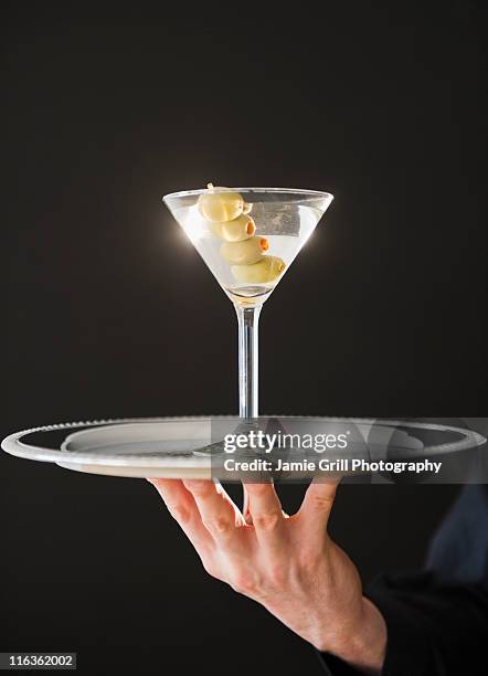 hand holding tray with martini - vaso de martini fotografías e imágenes de stock