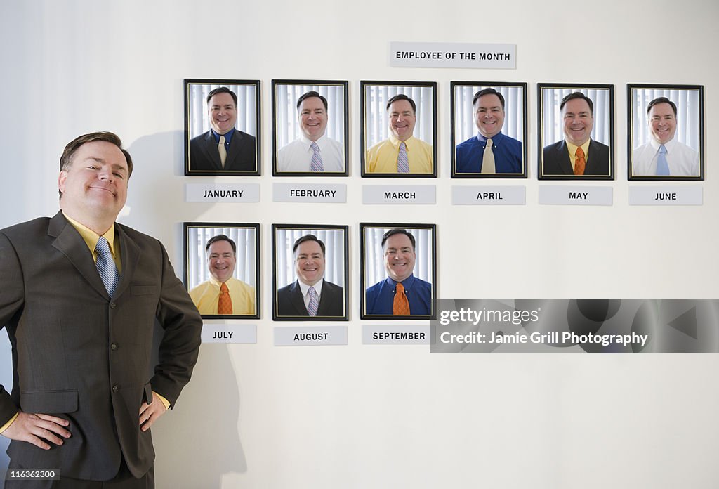 USA, Jersey City, New Jersey, businessman standing in front of employee of the month portraits