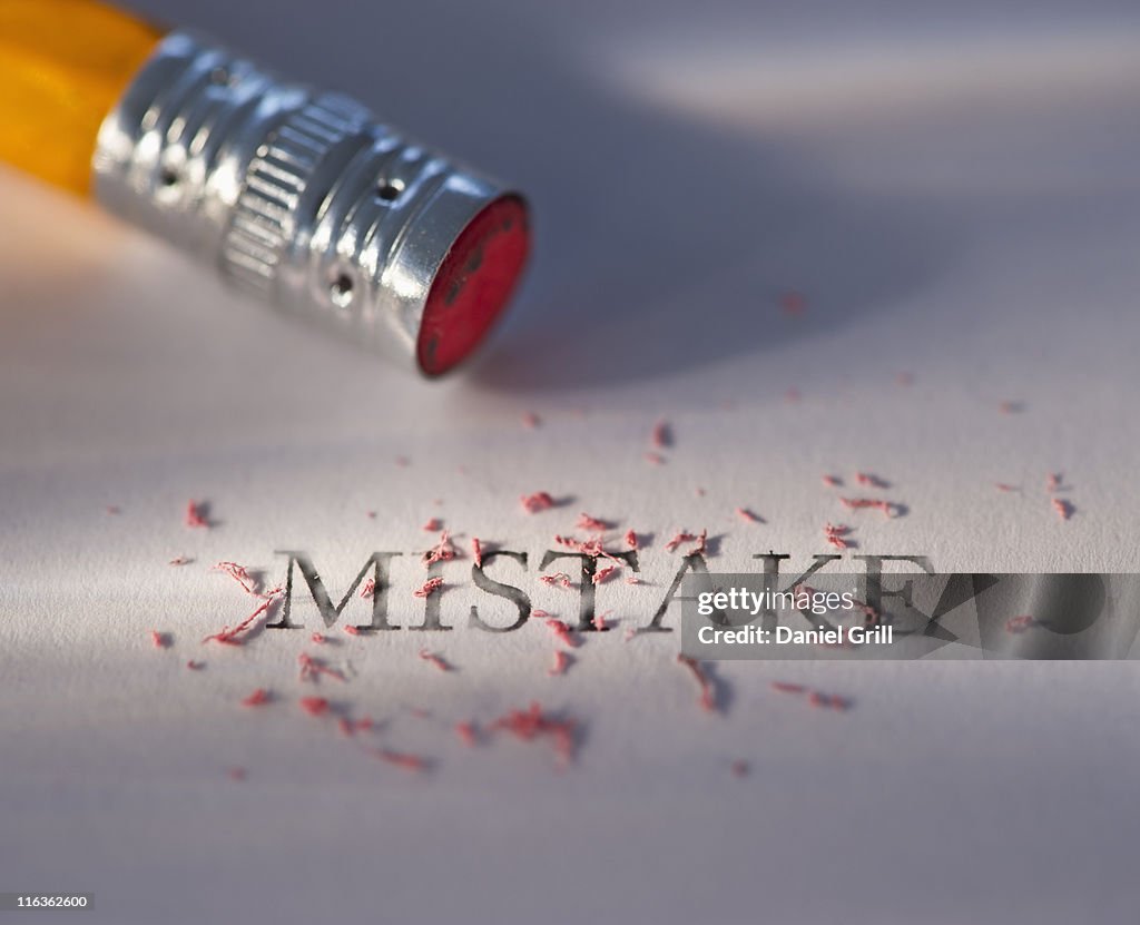 Studio shot of pencil erasing the word mistake from piece of paper