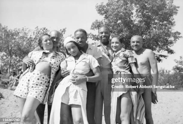 Portrait of a group of unidentified people as they pose on the beach outside the Idlewild Club House, Idlewild, Michigan, September 1938. Idlewild,...