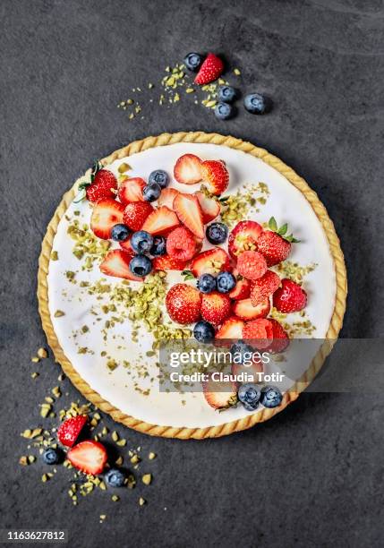 berry tart on black background - strawberries and cream stockfoto's en -beelden