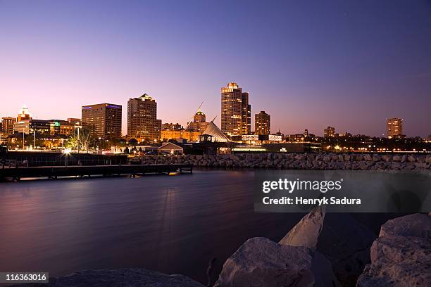 usa, wisconsin, milwaukee skyline across lake at dusk - milwaukee skyline stock-fotos und bilder