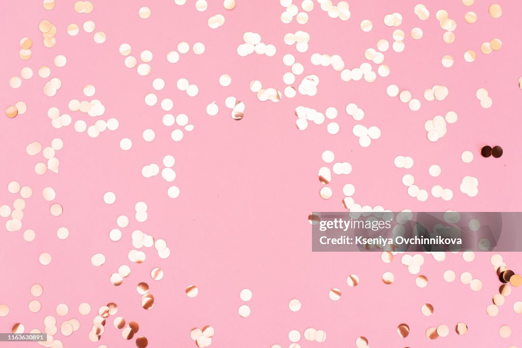 Golden sparkles on pink pastel trendy background. Festive backdrop for your projects.