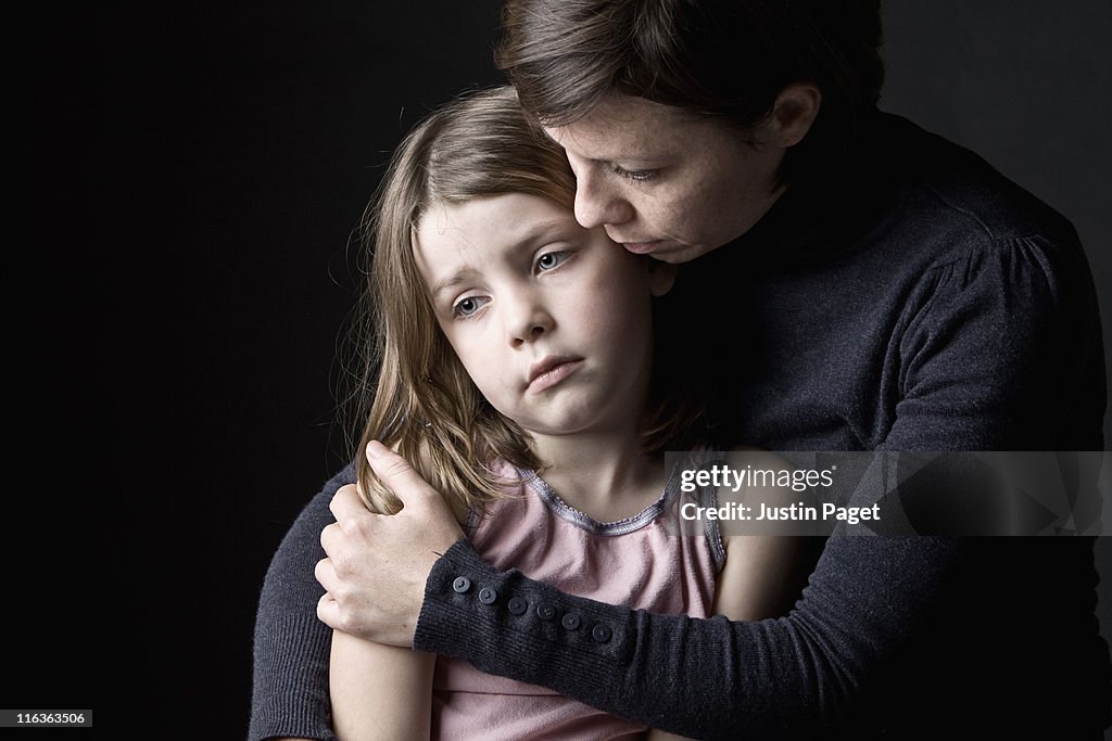 Mother and daughter (6-7) embracing