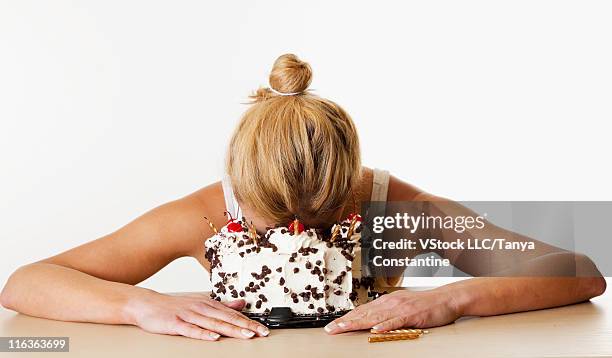 stidio shot of woman with face in birthday cake - sad birthday stock pictures, royalty-free photos & images