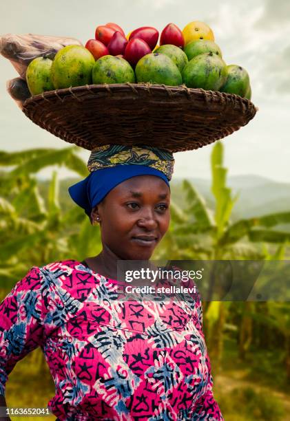 afrikanische frau porträt mit einem korb mit früchten auf dem kopf, ruanda - afrikanerin korb tragen stock-fotos und bilder