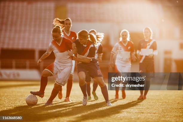 teenage girls in action during the soccer match on a playing field. - football tackling stock pictures, royalty-free photos & images