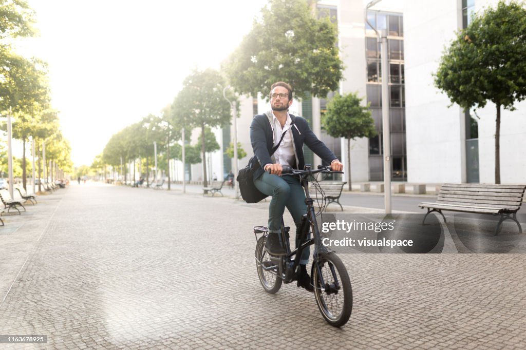 Männlicher Pendler mit Elektrofahrrad in Mitte