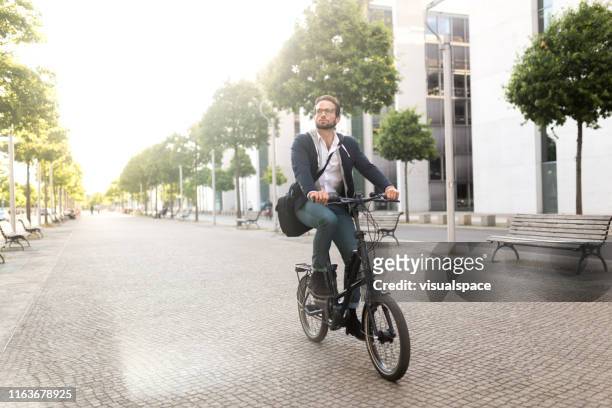 pendolare maschio con bici elettrica a mitte - city bike foto e immagini stock
