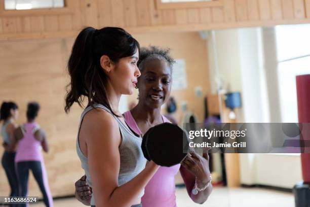 woman with personal trainer lifting weights in gym - personal training stock pictures, royalty-free photos & images