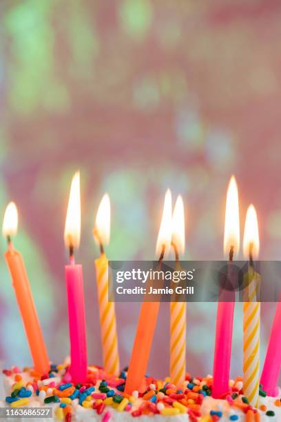 lit candles on birthday cake - birthday candle stock pictures, royalty-free photos & images