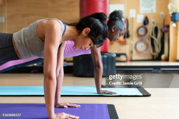 women doing yoga in gym - woman press ups stock pictures, royalty-free photos & images