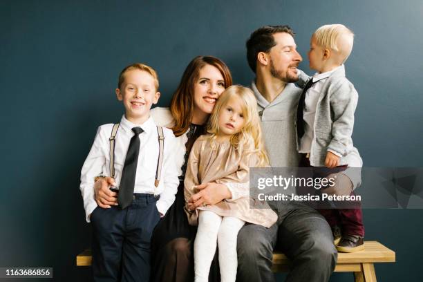 family sitting on bench - cinco personas fotografías e imágenes de stock