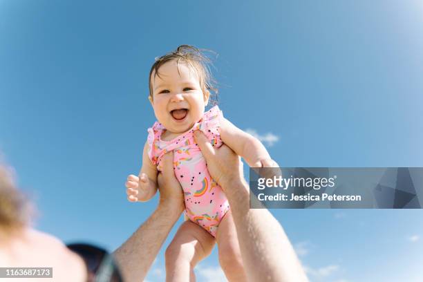 father holding his baby girl aloft - baby sommer stockfoto's en -beelden