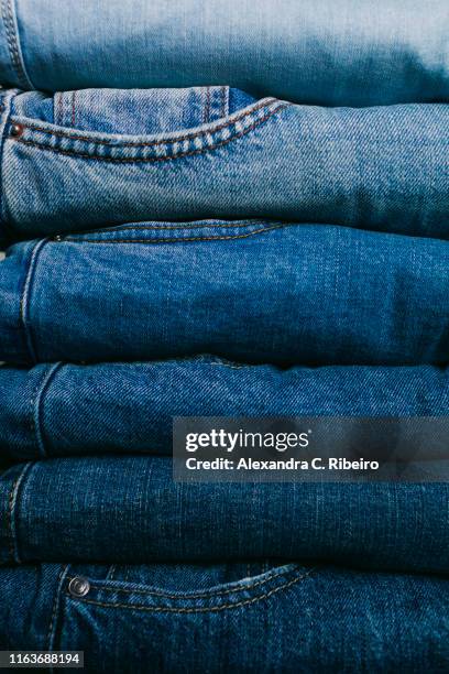 stack of folded jeans - folded clothes stock-fotos und bilder