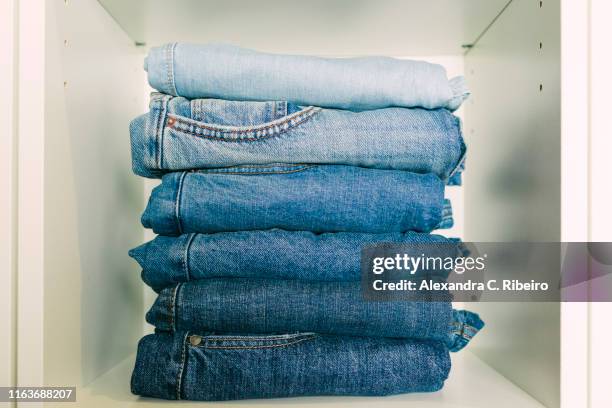 stack of folded jeans - denim stock pictures, royalty-free photos & images