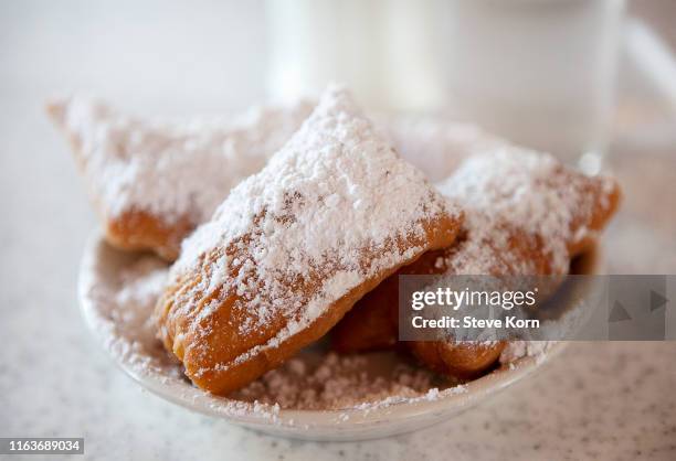 beignets with powdered sugar on plate - new orleans stock pictures, royalty-free photos & images