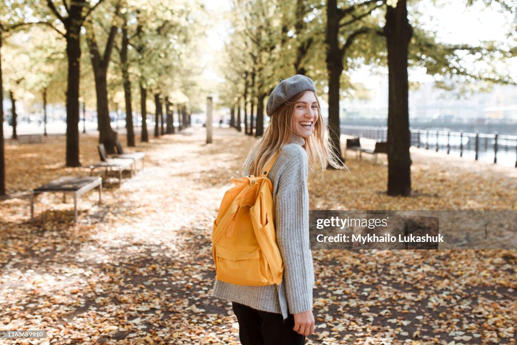 Young woman with yellow backpack in park in Berlin, Germany