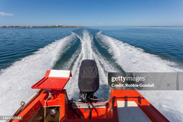 speeding across the ocean in a red fishing boat - speed boat stock pictures, royalty-free photos & images