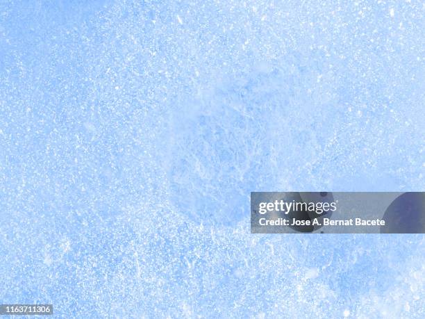 full frame of the textures formed of a block of cracked ice on a soft blue color background. - frost stock photos et images de collection