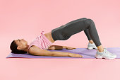 Fitness woman doing hip workout exercise on yoga mat at studio