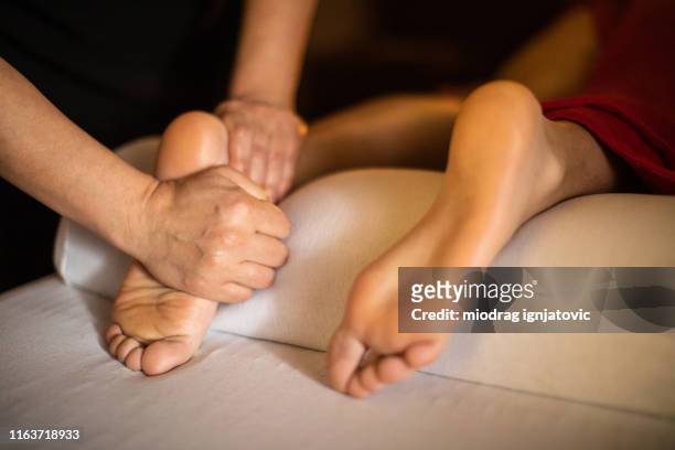 spa foot massage - woman lying on stomach with feet up stock pictures, royalty-free photos & images