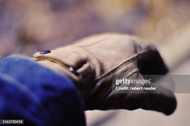 hand wearing leather working gloves - work glove - fotografias e filmes do acervo