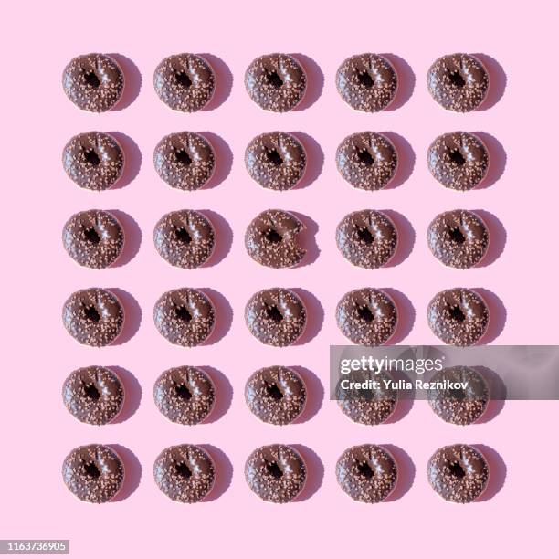 chocolate doughnuts on pink background - chocolate square stock pictures, royalty-free photos & images