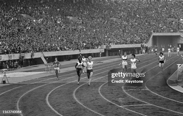 Ewa Klobukowska of the Poland team breaks the tape ahead of Edith McGuire of the United States and Dorothy Hyman of the Great Britain team to win the...