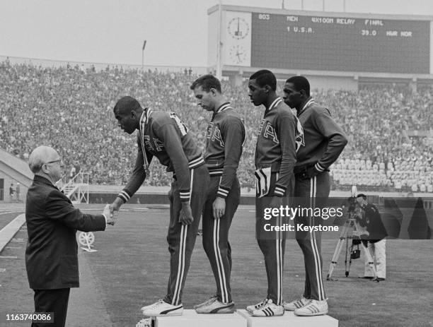 Avery Brundage, President of the International Olympic Committee presents the winning gold medals to Otis Paul Drayton, Gerald Ashworth, Richard...