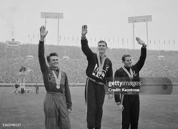 Gold medallist Peter Snell of New Zealand celebrates with silver medallist Josef Odlozil of Czechoslovakia and bronze medal winning compatriot John...
